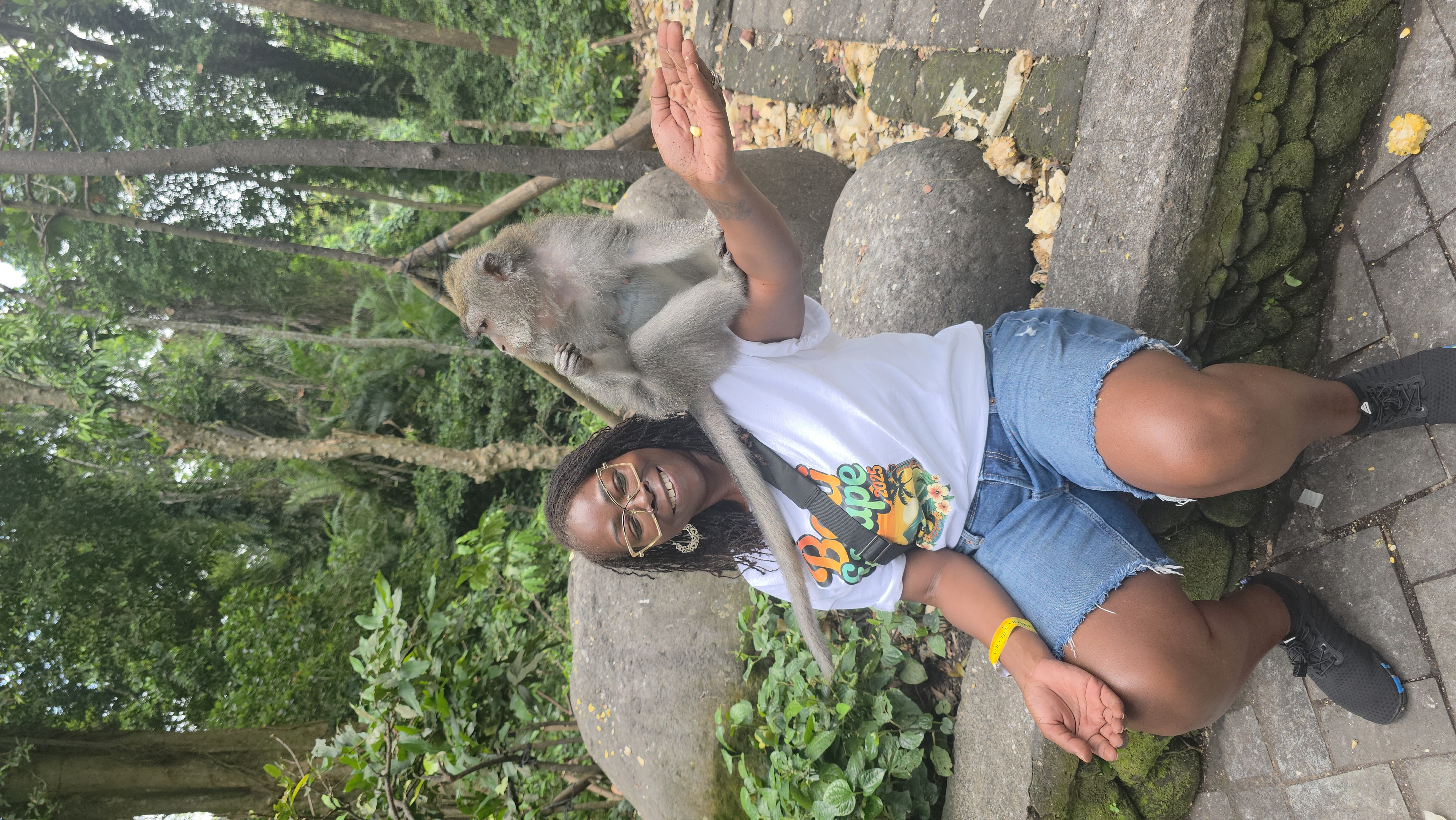 Traveler feeding a monkey near Uluwatu, Bali